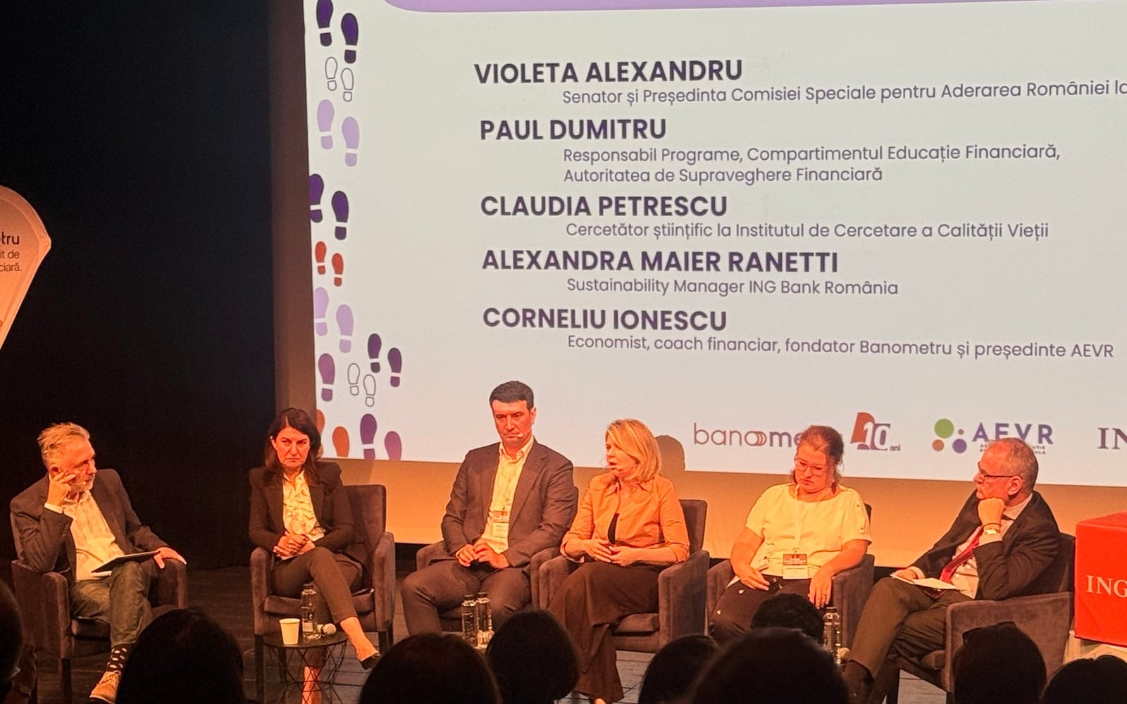 Șase invitați pe scenă, în fața ecranului cu titlul Cum construim reziliența financiară a românilor