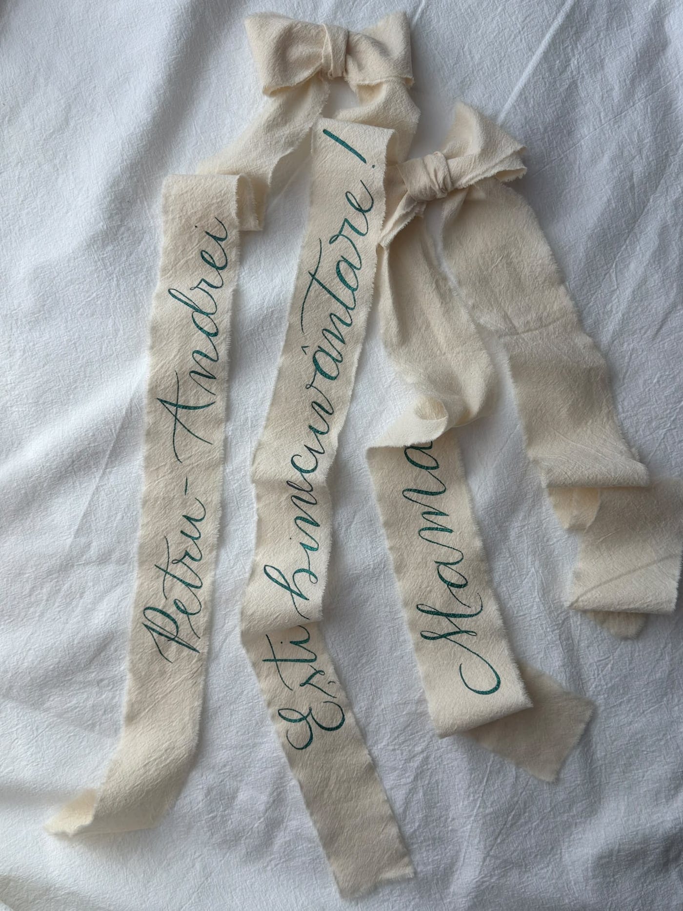 Trei panglici de bumbac crem, caligrafiate cu cerneală verde
