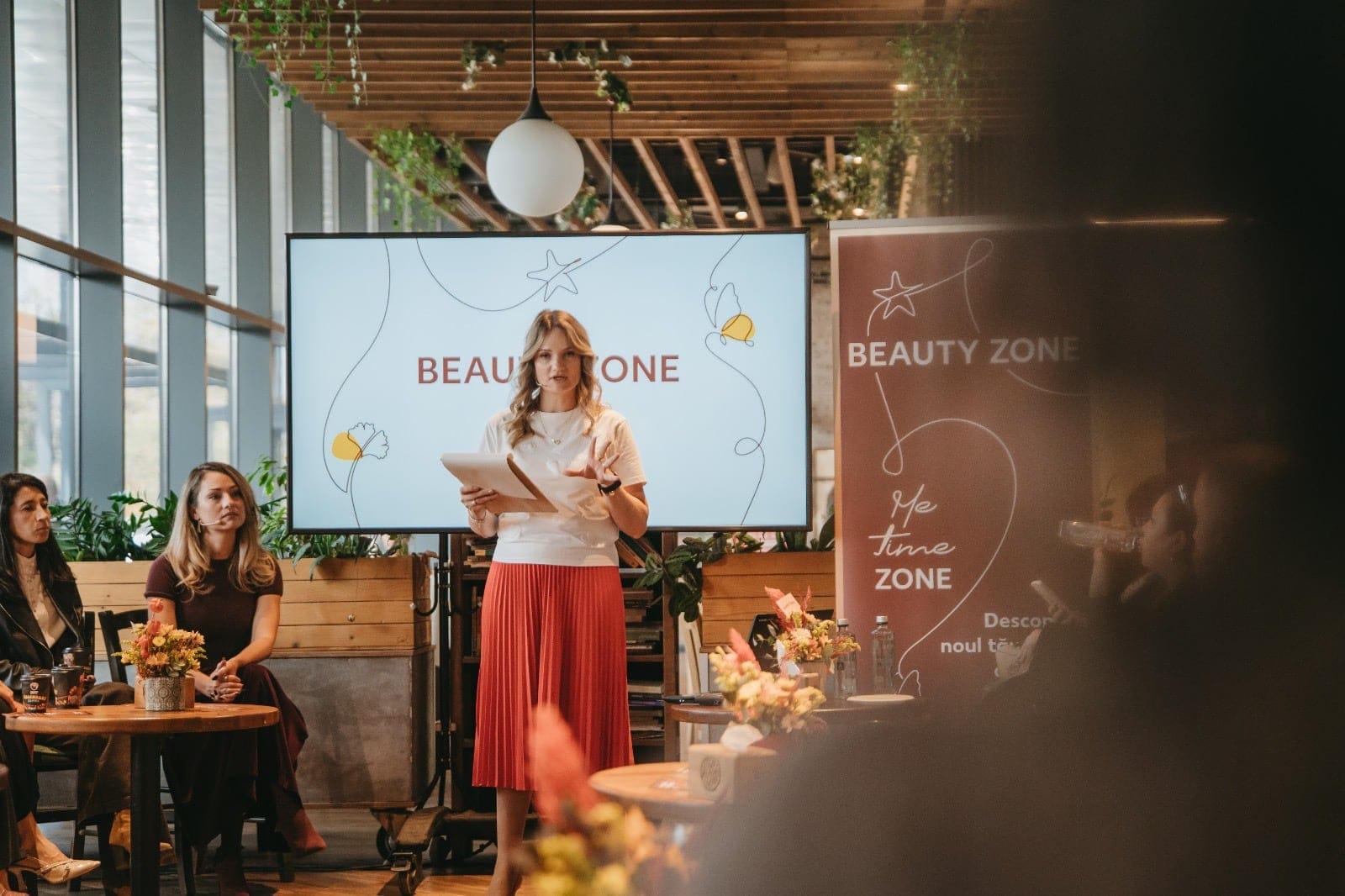 Prezentare pe scenă la lansarea conceptului Beauty Zone, cu ecranul și bannerul Beauty Zone în spate