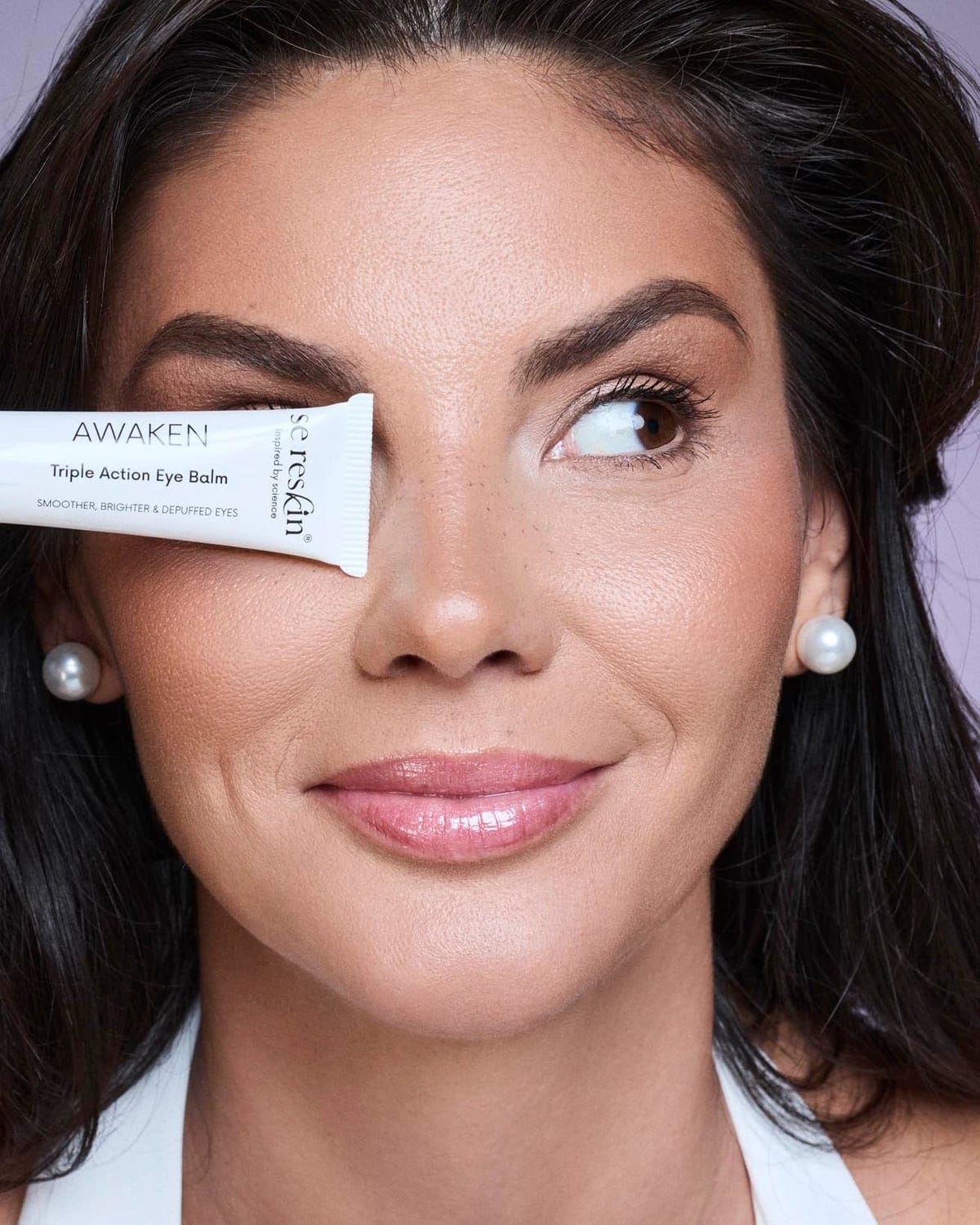 Femeie care aplică pe pleoapă crema pentru ochi Sereskin Awaken