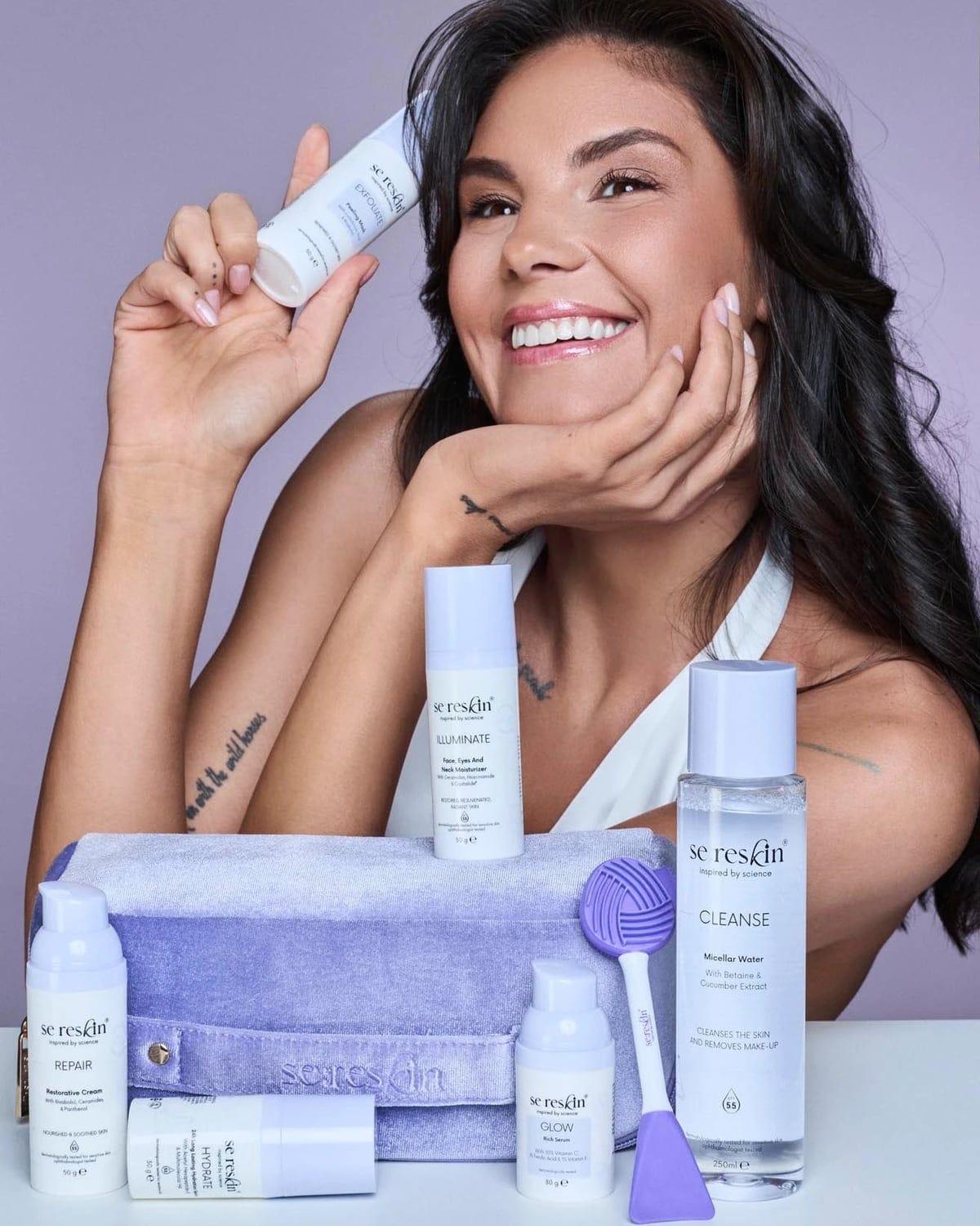 Femeie zâmbind, cu mai multe produse Sereskin în față