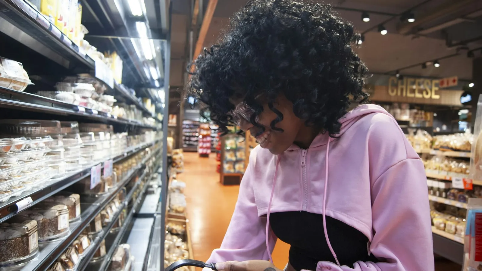 O tânără face cumpărături pe un culoar de supermarket