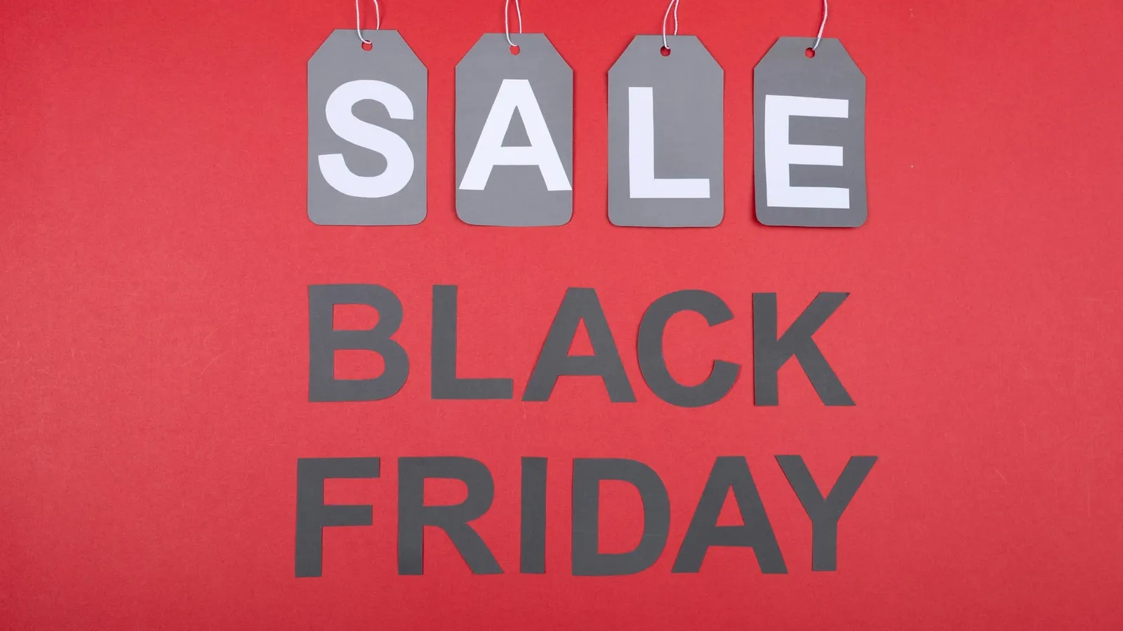 Etichete cu „SALE” și inscripția „Black Friday” pe un fundal roșu
