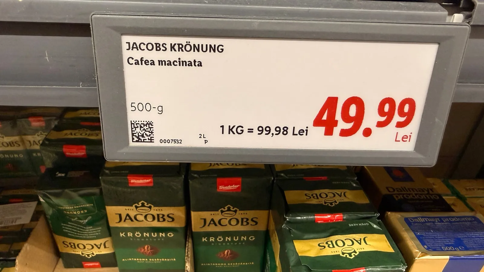 Raft cu cafea Jacobs Krönung și eticheta de 49,99 lei pentru punga de 500 de grame