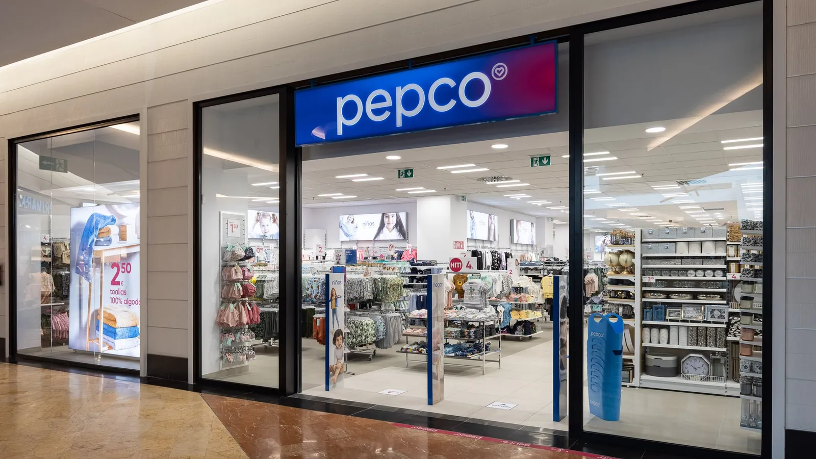 Intrarea unui magazin Pepco dintr-un centru comercial, cu haine pentru copii și produse pentru casă