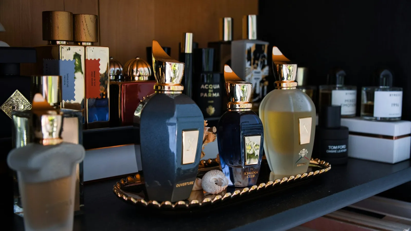 Sticle de parfum de diferite mărci așezate pe un raft