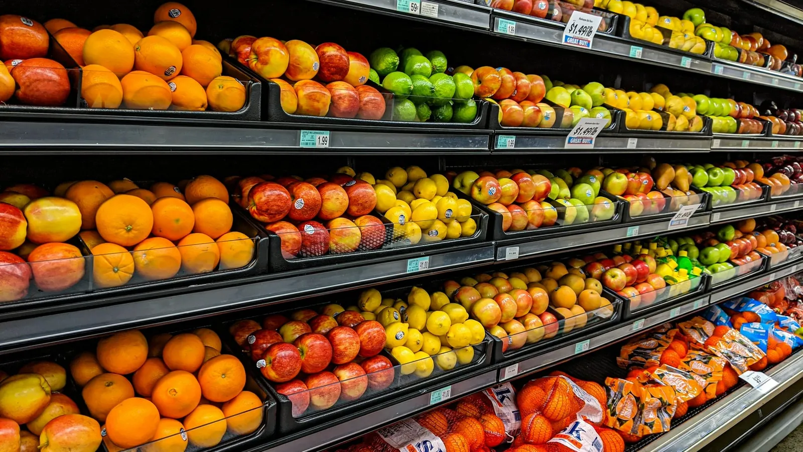 Rafturi cu portocale, mere, lămâi și lime într-un supermarket