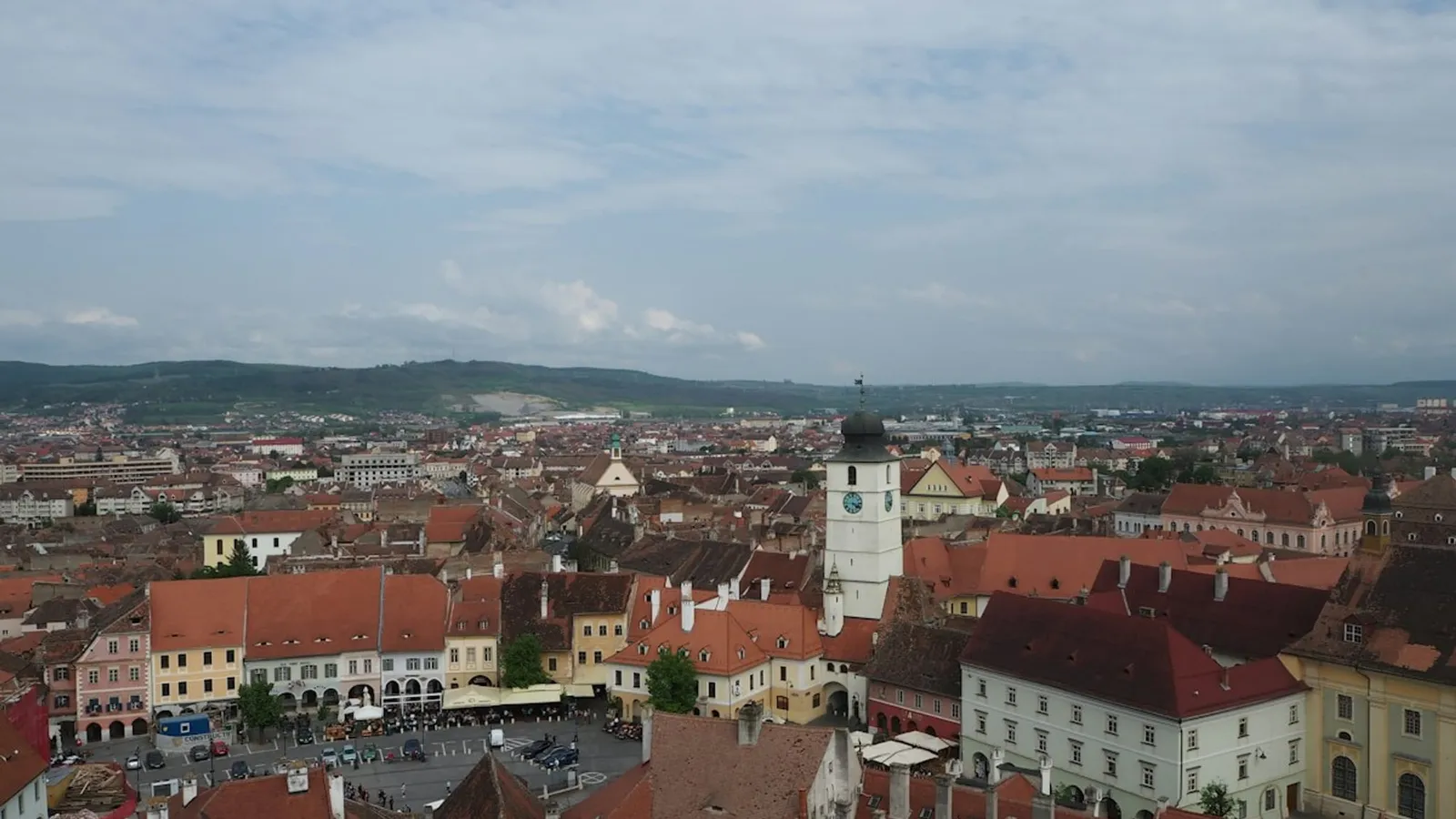 Panorama orașului Sibiu, cu acoperișuri roșii și turnuri, sub un cer înnorat