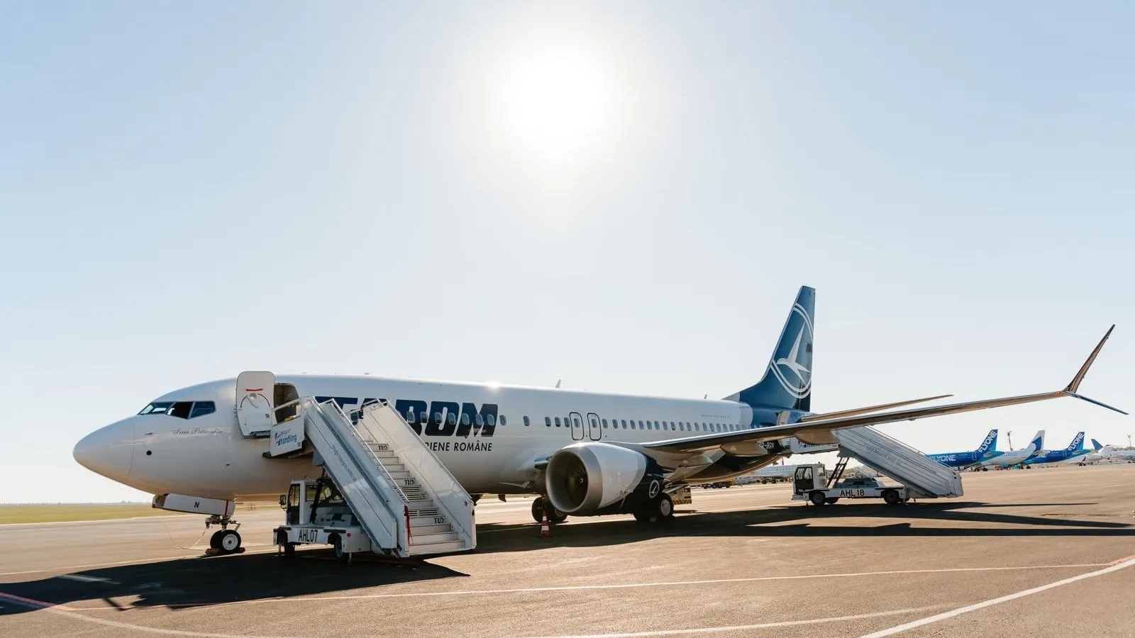 Avionul Boeing 737 MAX 8 al TAROM pe pista aeroportului, cu scara de îmbarcare atașată